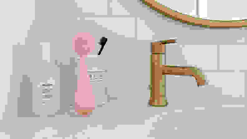 A pink PMD Brush on a kitchen sink