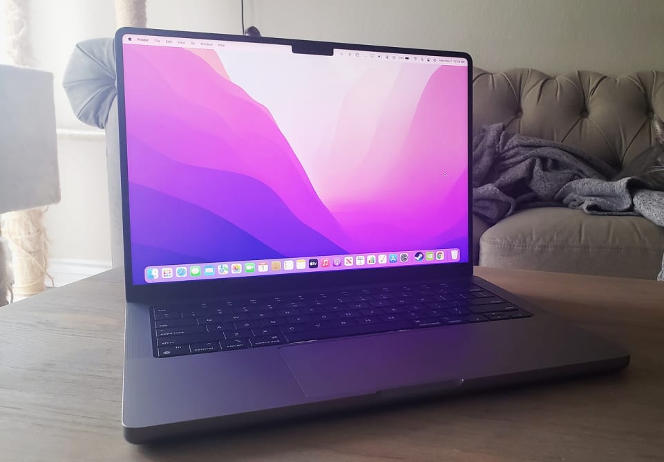An open laptop on top of a coffee table showing the desktop wallpaper