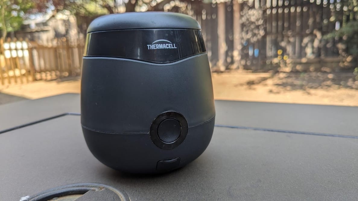 Black Thermacell E55 Mosquito Repellent device sitting on top of table outdoors.