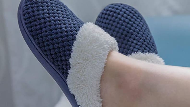 Cozy slippers on a pair of feet.