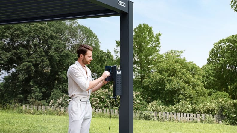 A man sitting under a FlexPatio motorized pergola