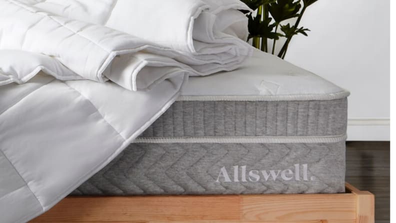 Allswell mattress with a duvet on top and brown wood bedframe