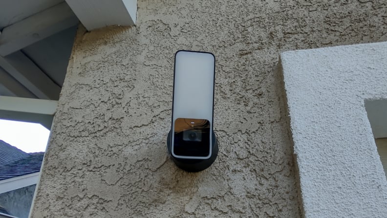 La Eve Cam Outdoor installée à côté d'un garage