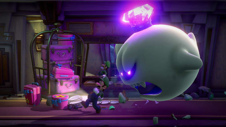 Luigi is being chased by a big ghost monster down a dark and dusty hallway.