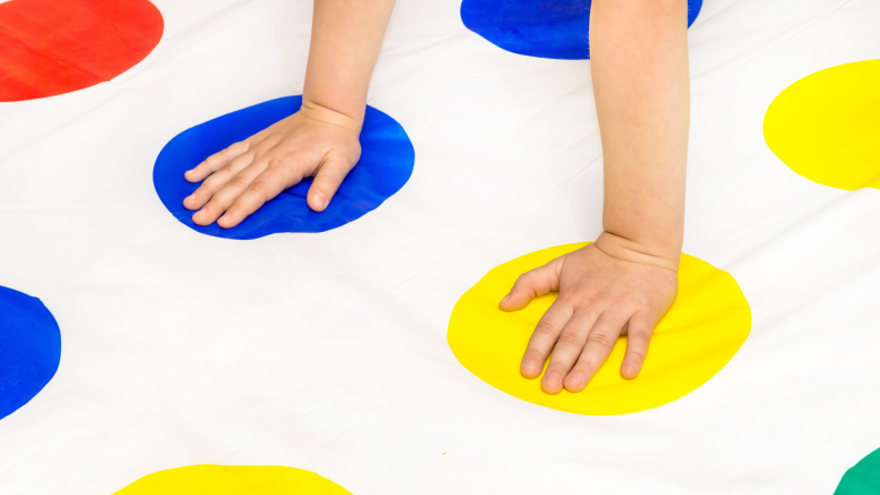 A person plays Twister on a floor.