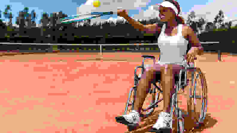 Paralympic tennis player looking happy with a racket