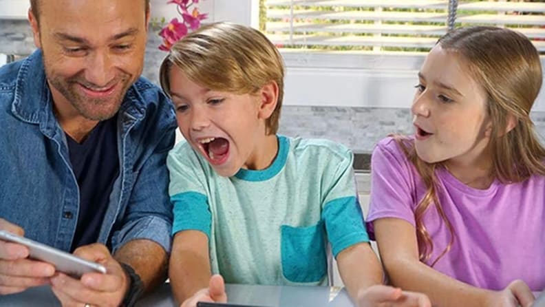 Father playing with two children on smartphone.