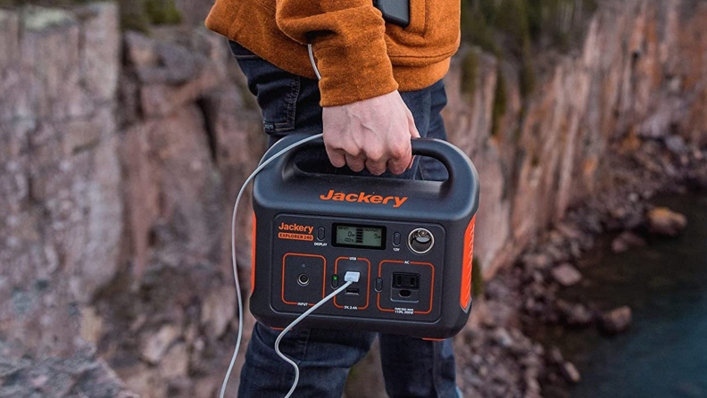 A person carries a battery generator outside.