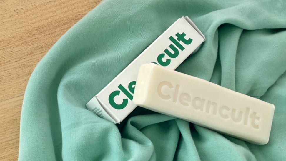 A Cleancult cleaning bar lays on a green towel.