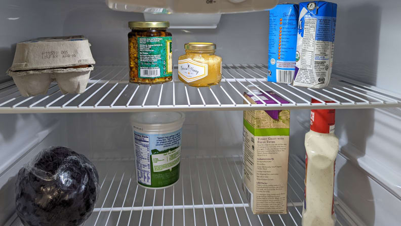 A close-up picture of a refrigerator's wire shelf.  They have stock of food.