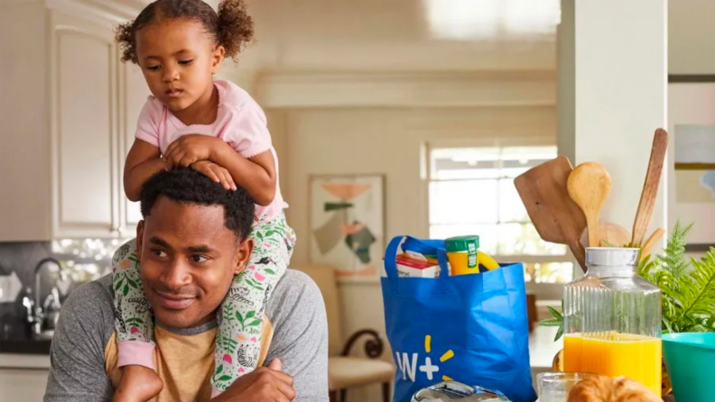 A parent hoists a child over their shoulders.