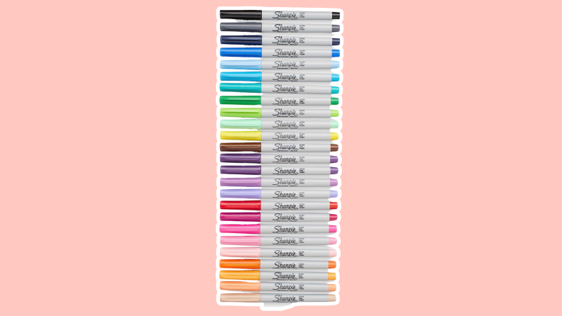 A row of Sharpie pens in different colors on a pink background.