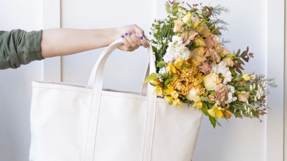 Person holding an LL Bean bag with a bouquet in it