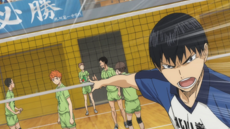 A still from the series Haikyu!! featuring an opponent pointing angrily at the main character through a volleyball net.