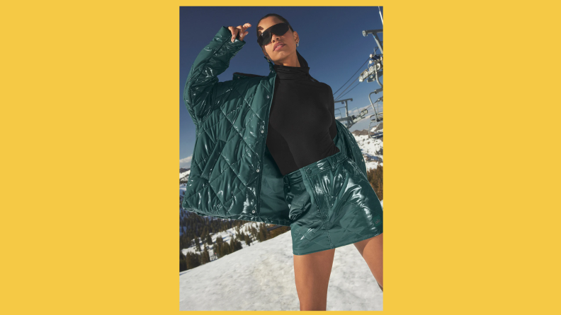 A model wearing a green puffer skirt with matching jacket out in the snow.
