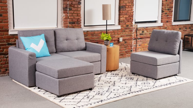 The gray Linsy Home couch rearranged to be a loveseat and chair.