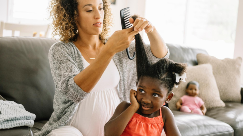 Mother brushing out daughter's hair