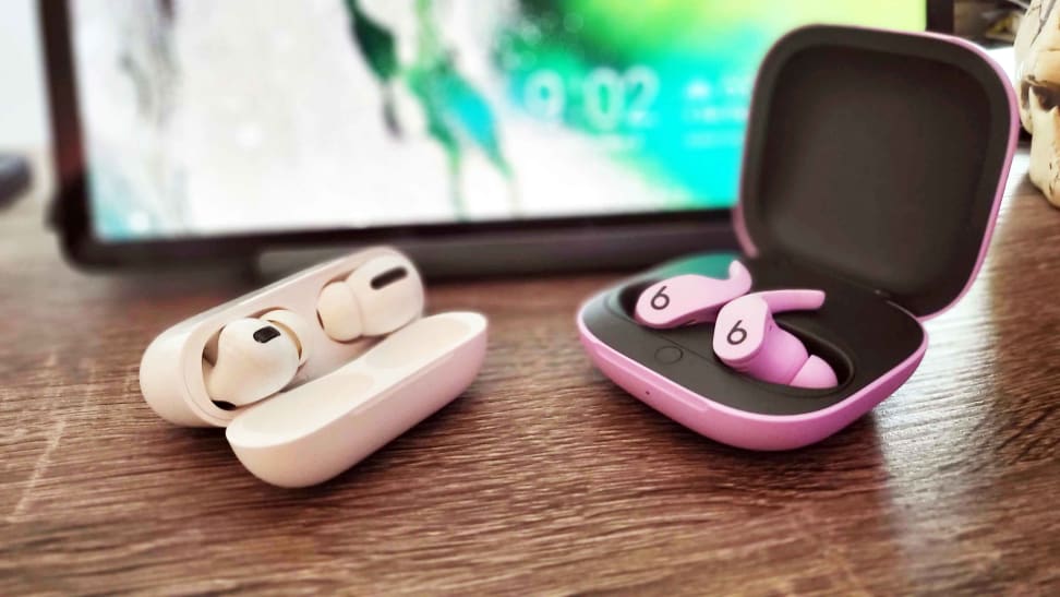 The Apple AirPods Pro and Beats Fit Pro side by side in front of a tablet