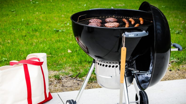 Weber charcoal grill with burgers
