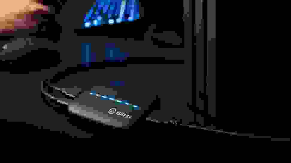 An Elgato capture card is plugged into a PlayStation 4 for broadcasting footage on a connected PC.