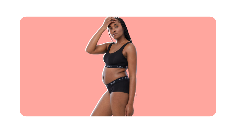Pregnant person wearing two-piece black sports ra and underwear set from Ingrid+isabel with hand on forehead.