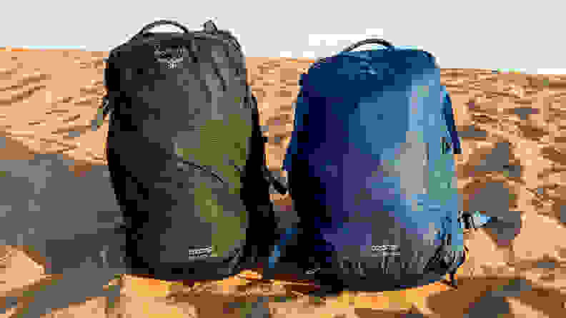 Two Osprey Ozone Duplex travel backpacks sit in sand in the Sahara Desert.