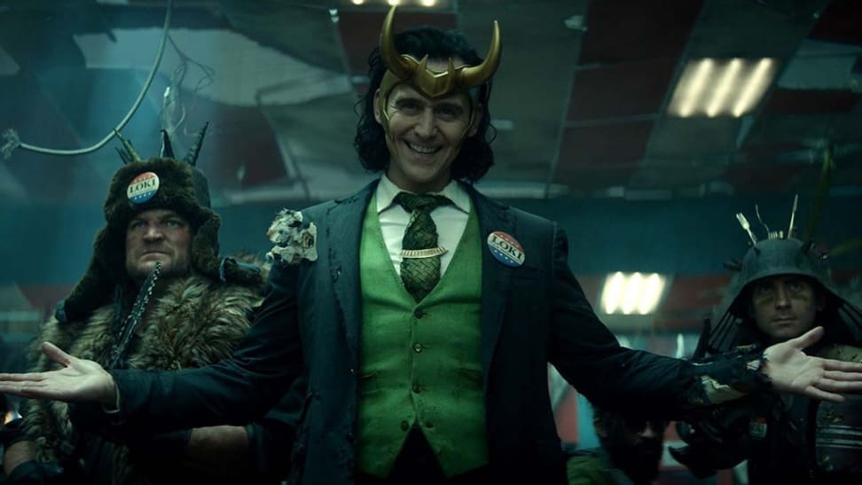 Evil villain, Loki, looks menacing as he stands with his henchmen holding weapons.