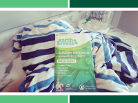 Box of Earth Breeze eco-friendly laundry sheets on top of towel next to jar of powdered laundry