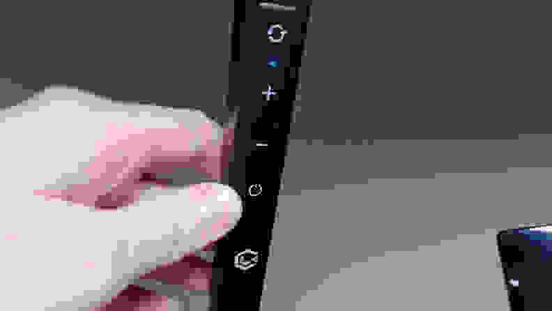An LED Light from Lume Cube with a hand posed next to the controls