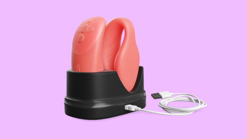 The We-Vibe vibrator inside a black stand, next to a USB charger.