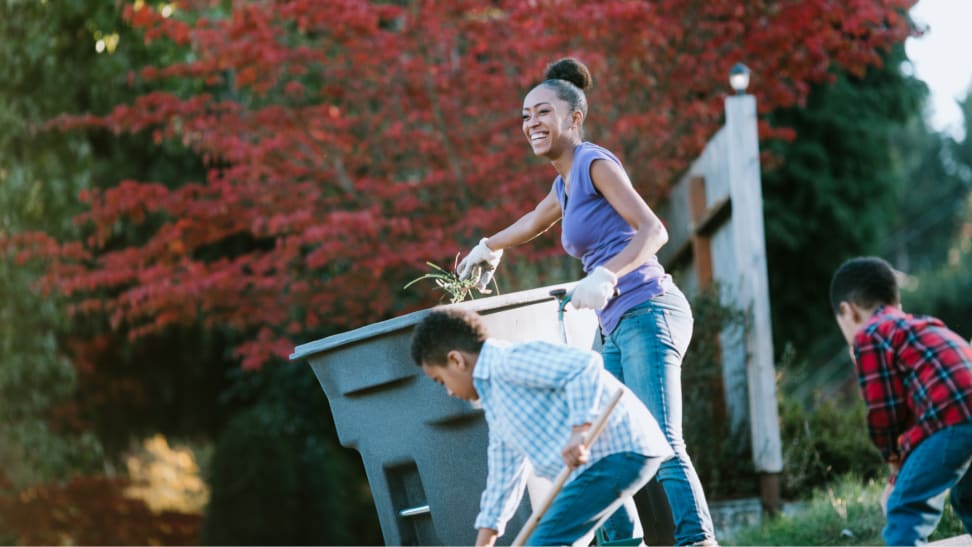 Family cleaning up a yard in fall