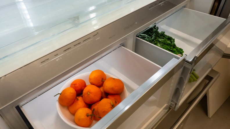 Fresh oranges and kale in crisper draw.