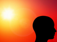 A bald head silhouette on a red background with a blazing sun