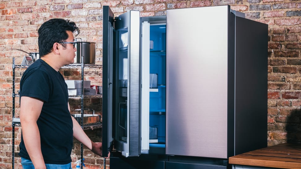 A person pulling a door open on a French-door refrigerator