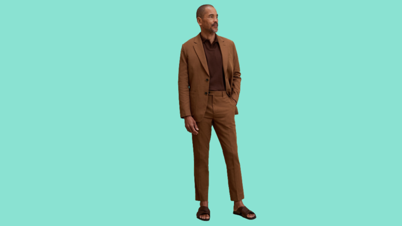 A model wearing a brown suit with sandals.