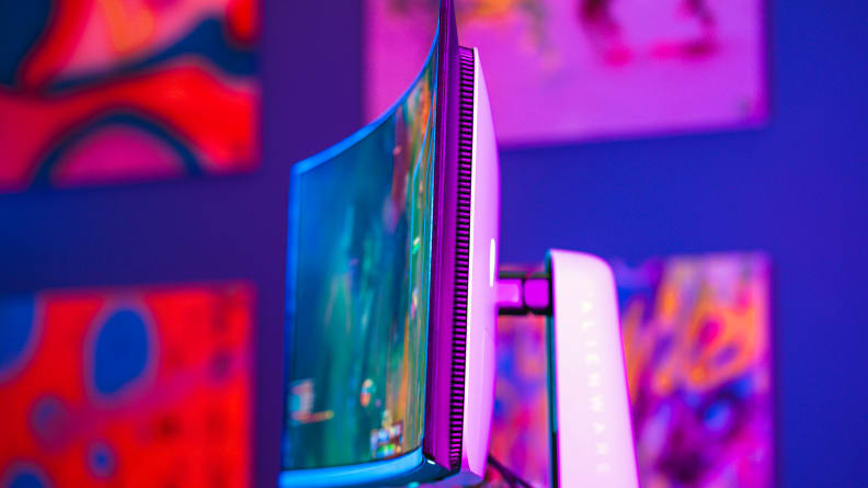 A monitor on top of a desk with a colored background