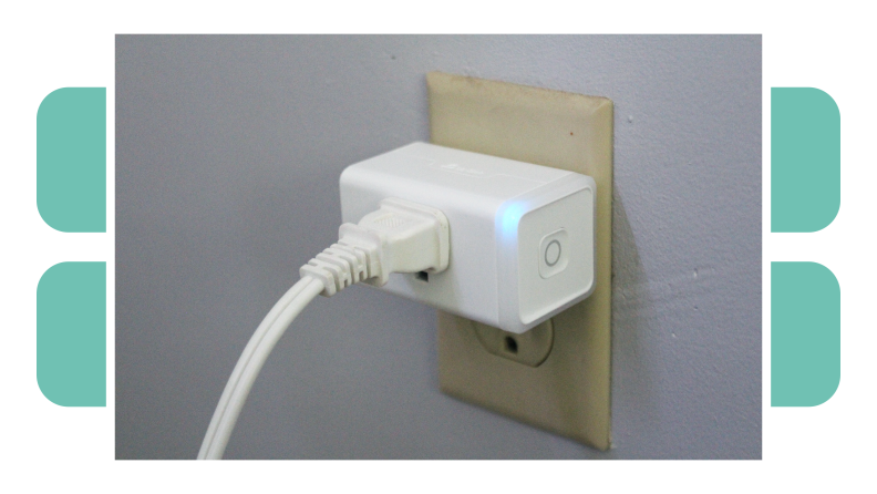 The Kasa Smart Wi-Fi Plug and Energy Monitoring plugged into an outlet with cord connected.