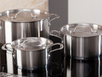 A set of stainless steel pots on an induction cooktop
