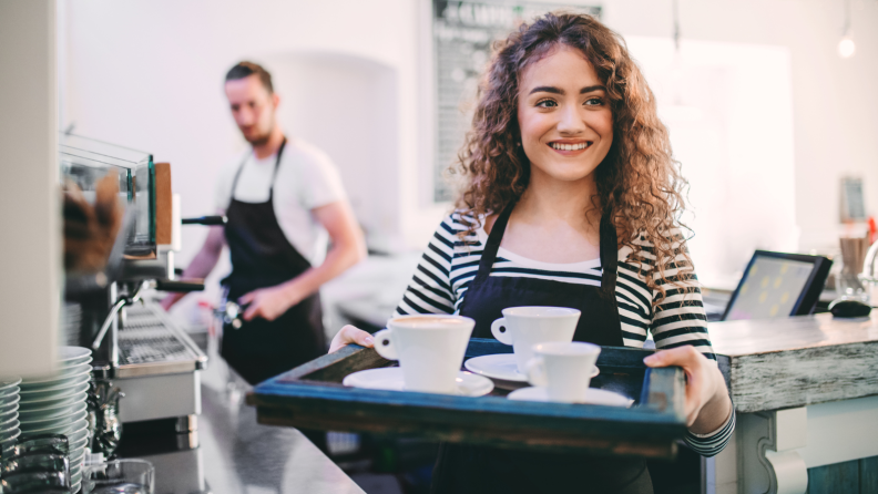 Woman holding a tray of coffee cups