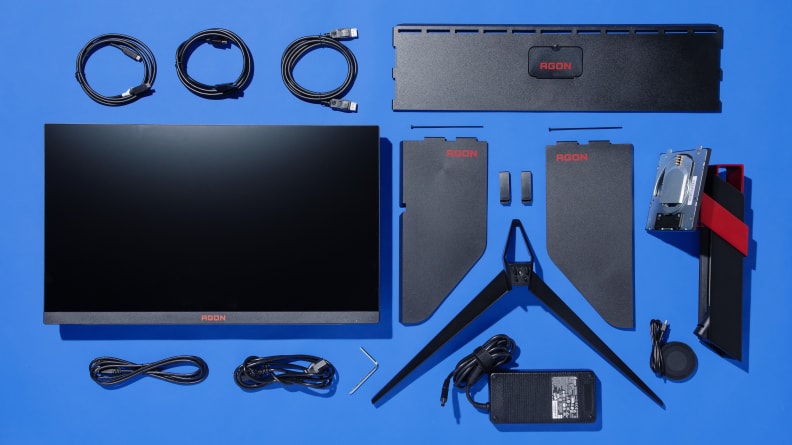 The AGON PRO monitor and accessories laid out next on a blue background.