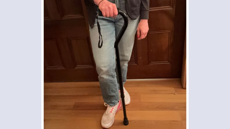 Person standing next to the Nova Heavy Duty Walking Cane with Offset Handle while firmly grasping the handle.