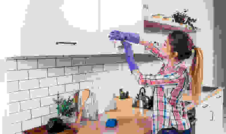 Woman wiping cabinets