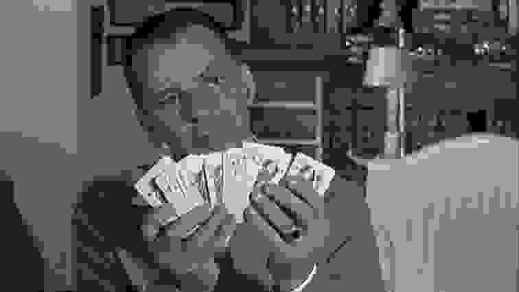 Frank Sinatra holding playing cards in a scene from "The Manchurian Candidate," one of the best thrillers streaming now.