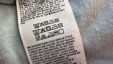 A clothing tag on a vest with wash instructions.