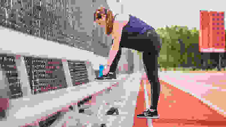 woman ties shoe while exercising