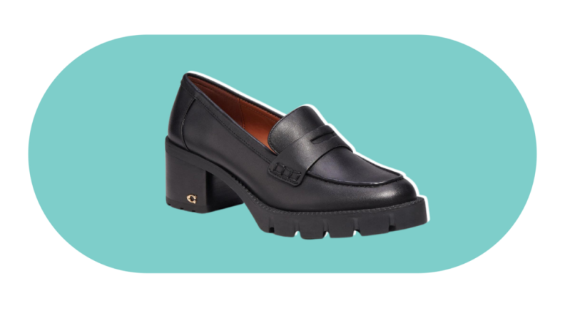 A black penny loafer with a block heel and lug sole. There is a small gold C emblem on the heel.