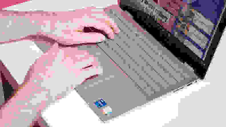 A person's hands graze the keyboard of the Dell Inspiron 14 7420.
