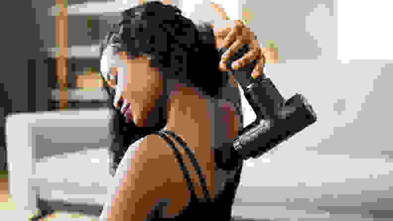 A woman using a massage gun