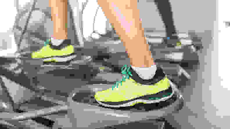 A close-up of someone's feet on an elliptical machine.