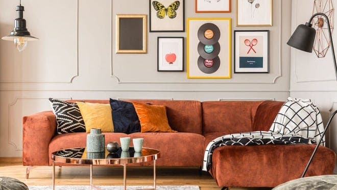 Burnt red colored suede couch in trendy living room